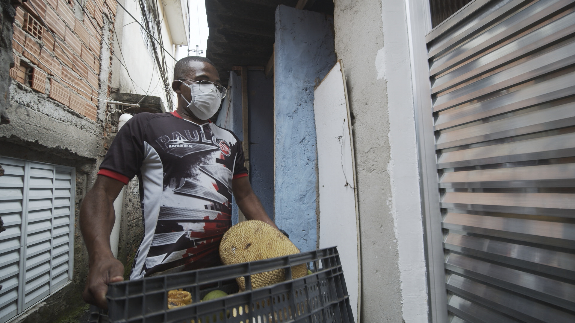 Lula Santos, do Projeto Meninas em Campo, distribui cesta de alimentos no Jardim São Remo, em São Paulo. Imagem extraída do filme "Do Quilombo pra Favela"|Manoela Meyer/ISA