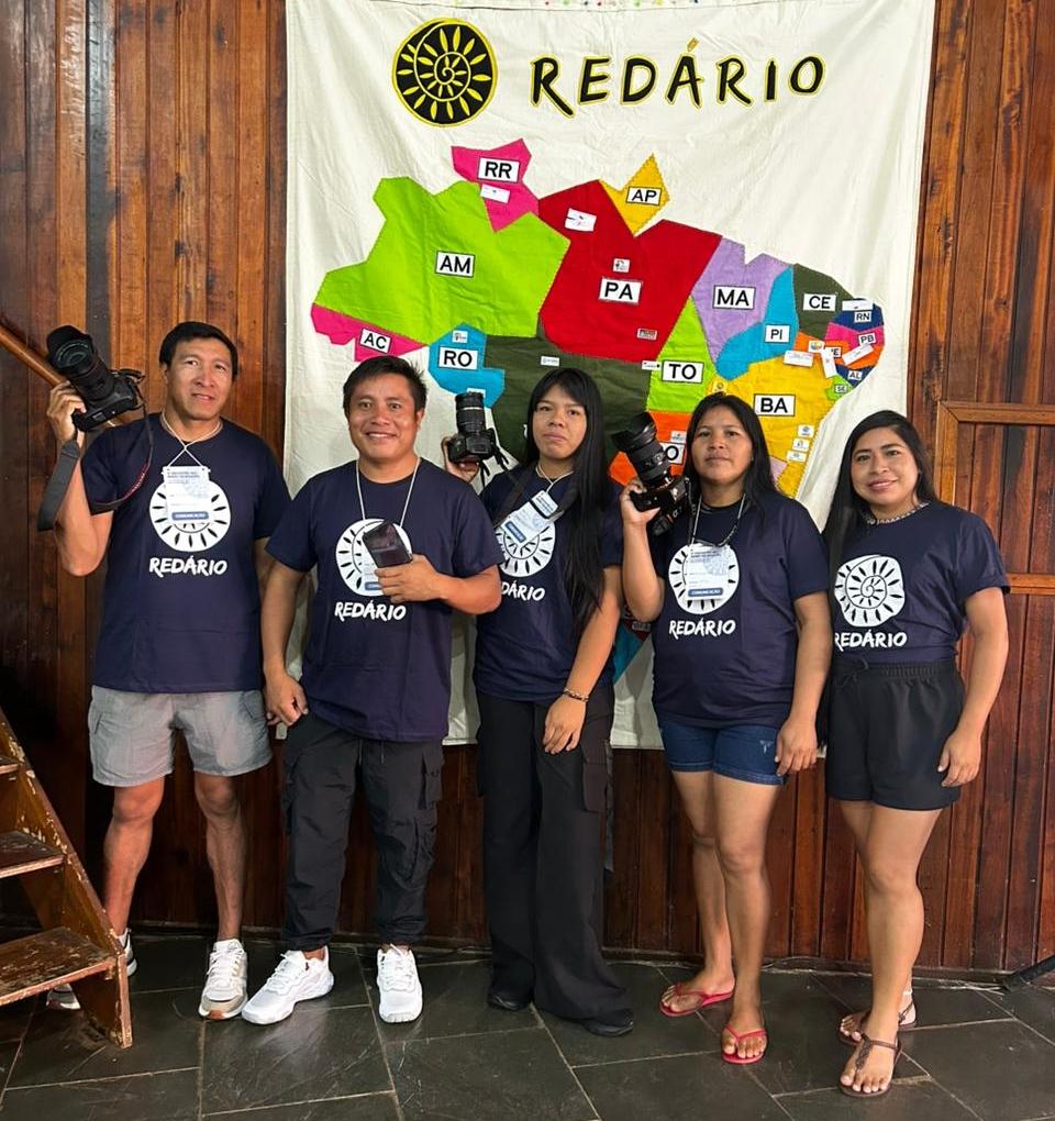 Comunicadores da Rede Xingu+ posam para foto em frente ao mapa do Brasil feito pelo Redário