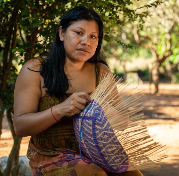 Lewaiki Khisêtjê posa para foto tecendo um cesto