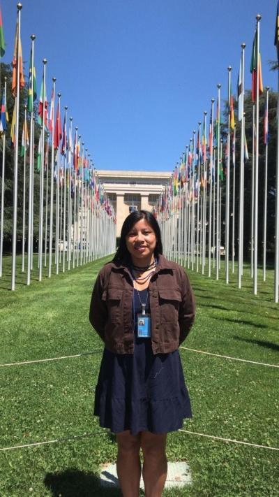 Lewaiki Khisêtjê no gramado da ONU. Atrás dela, tem bandeiras do mundo todo içadas